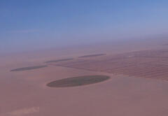 A circular farm that uses groundwater in the desert. Electricity is needed to pump up the groundwater.