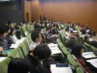 シンポジウムの様子。研究成果を発表する外国人研究者(左)と、真剣に耳を傾ける学生の参加者(右)たち。