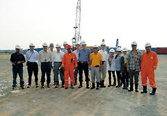 Indonesian and Japanese joint research team standing in front of a drill rig that is prepared to produce natural gas. The team was visiting the site to formulate research plans.