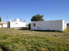 The Southern Patagonia observatory at Rio Gallegos, one of the sites in the observation network constructed for this research. The container at front right contains the millimeter-wave ozone observation system, and the container at the left contains an ozone observation system using lidar (laser radar).