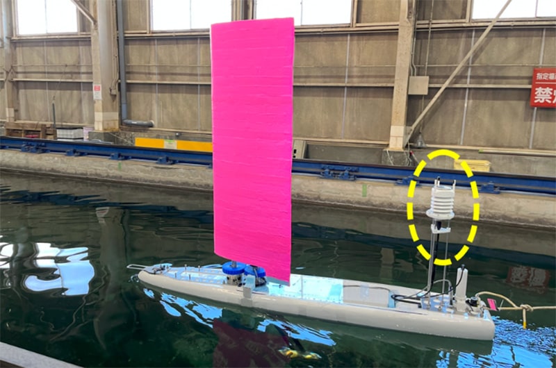 図1 VMドローン試作1号機に艤装された改修済み大気観測センサー（黄色破線）。国内沿岸海域試験実施に先立ち、代表機関の多目的水槽で静水中における測器検定を実施。